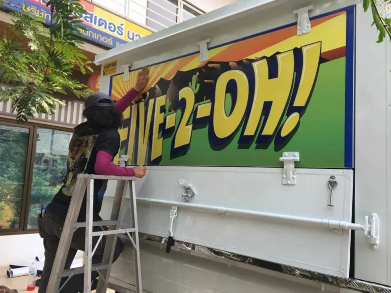 ช่างติดสติ๊กเกอร์ FIVE-2-OH! ข้างตู้รถ