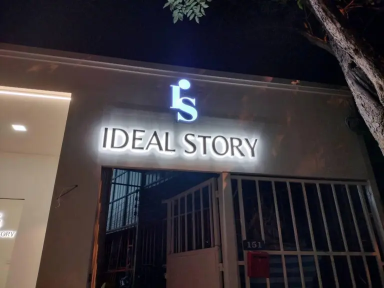 ป้ายไฟตัวอักษร IDEAL STORY หน้าร้านตอนกลางคืน