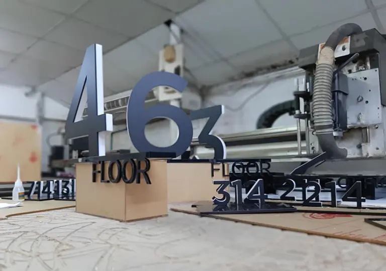 เครื่อง CNC เราเตอร์กับงานตัวเลขสามมิติที่เพิ่งตัดเสร็จในโรงงาน