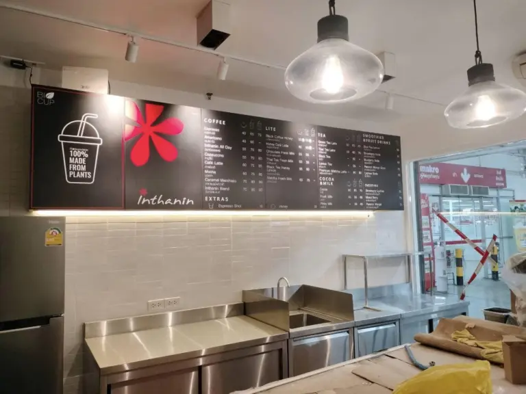 ป้ายเมนูติดผนังเหนือเคาน์เตอร์ร้านกาแฟ Inthanin